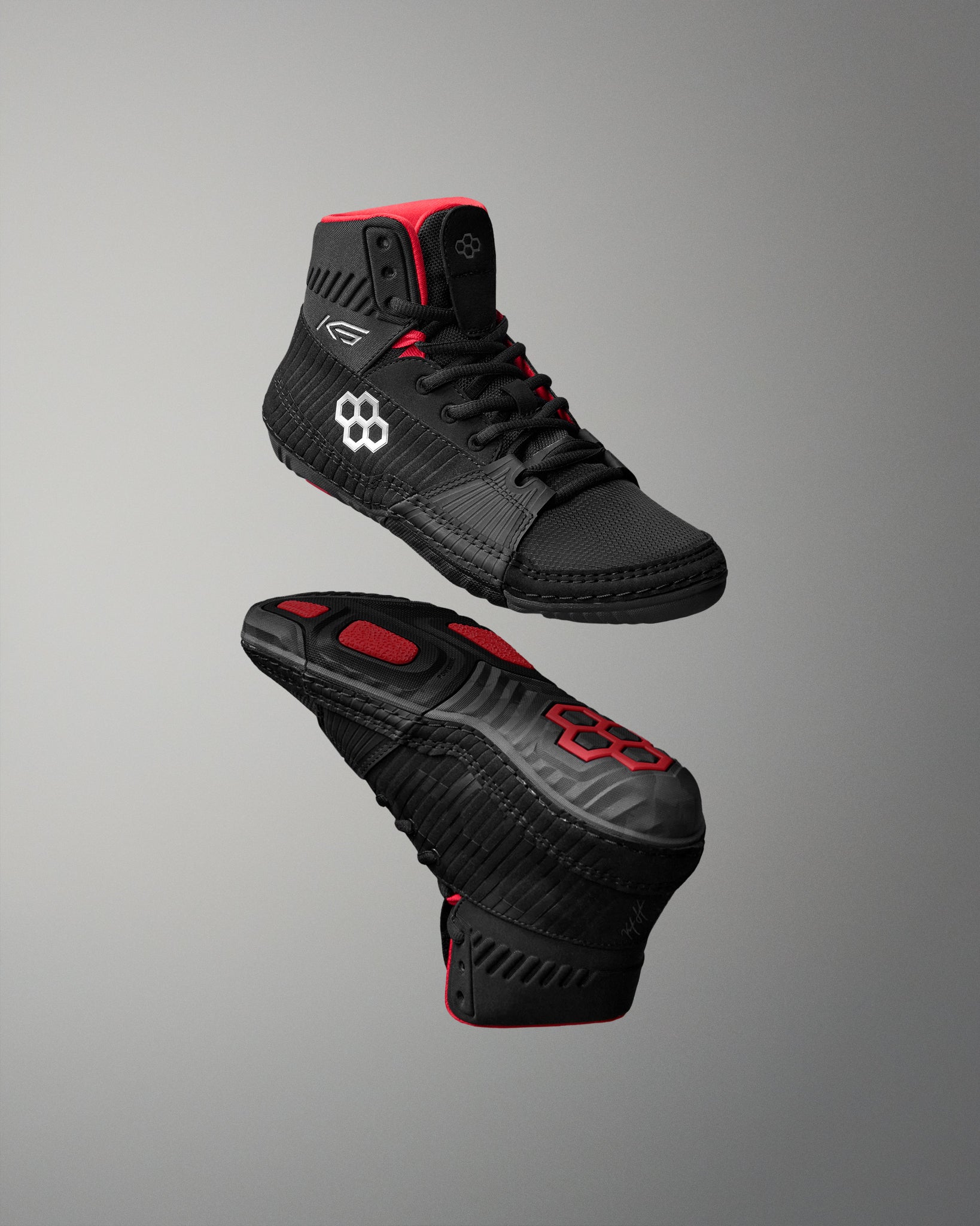 Black and red wrestling shoes on a gray background