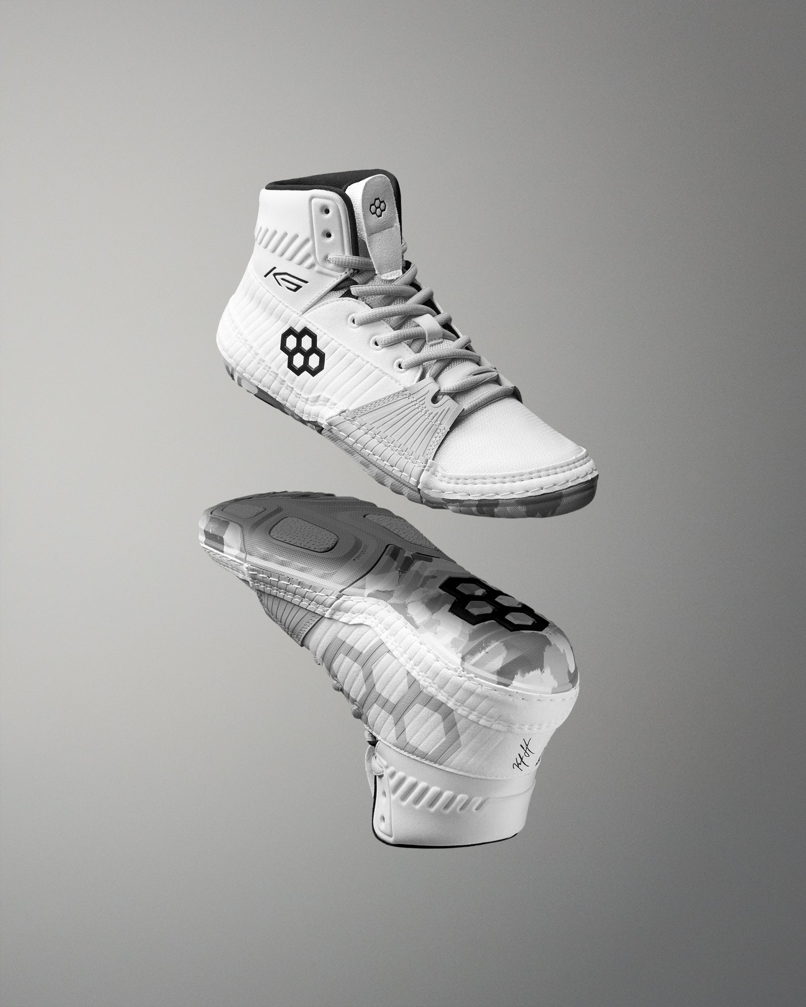 White wrestling shoes with black sole on a gray background