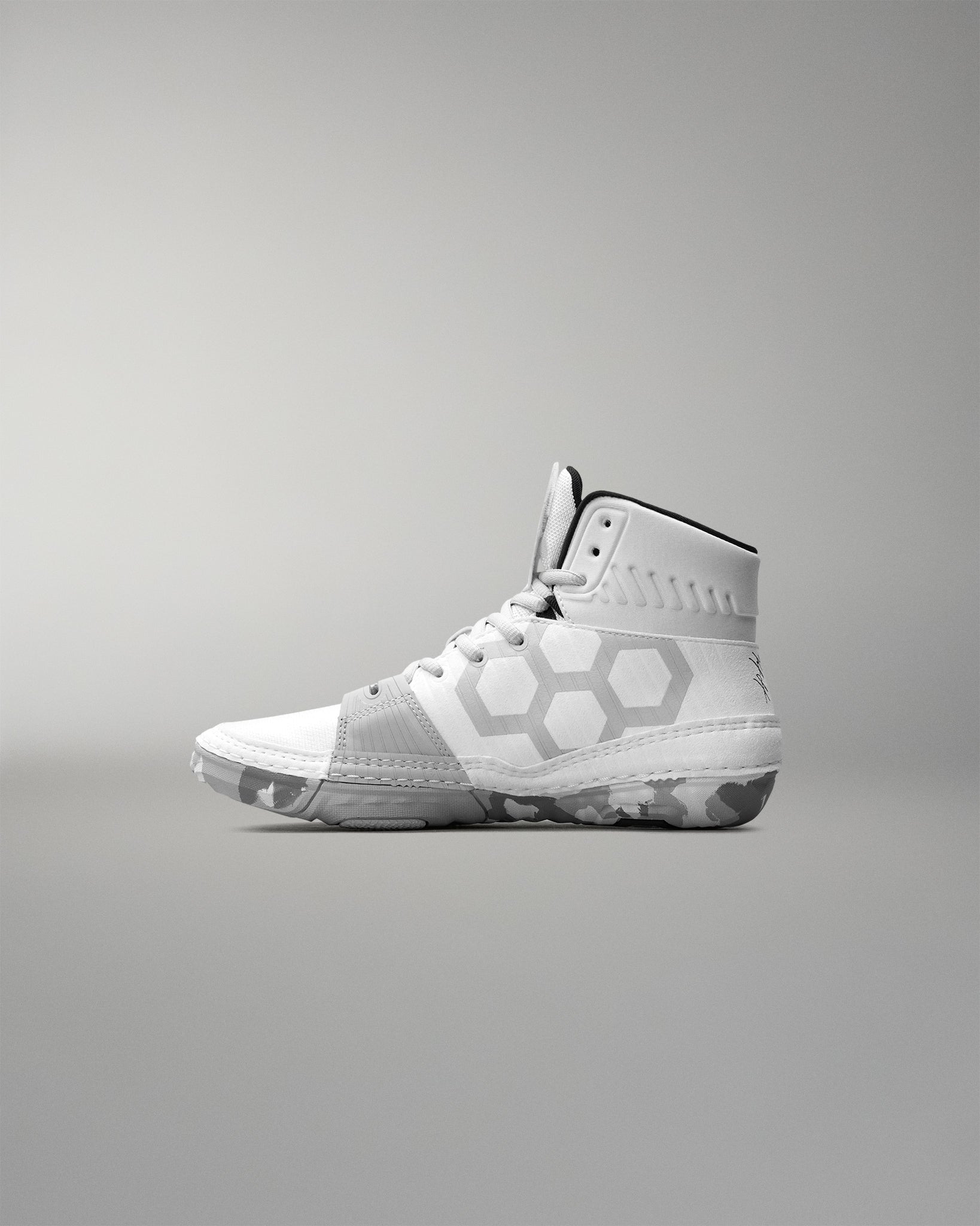 White wrestling shoe with geometric patterns on a gray background