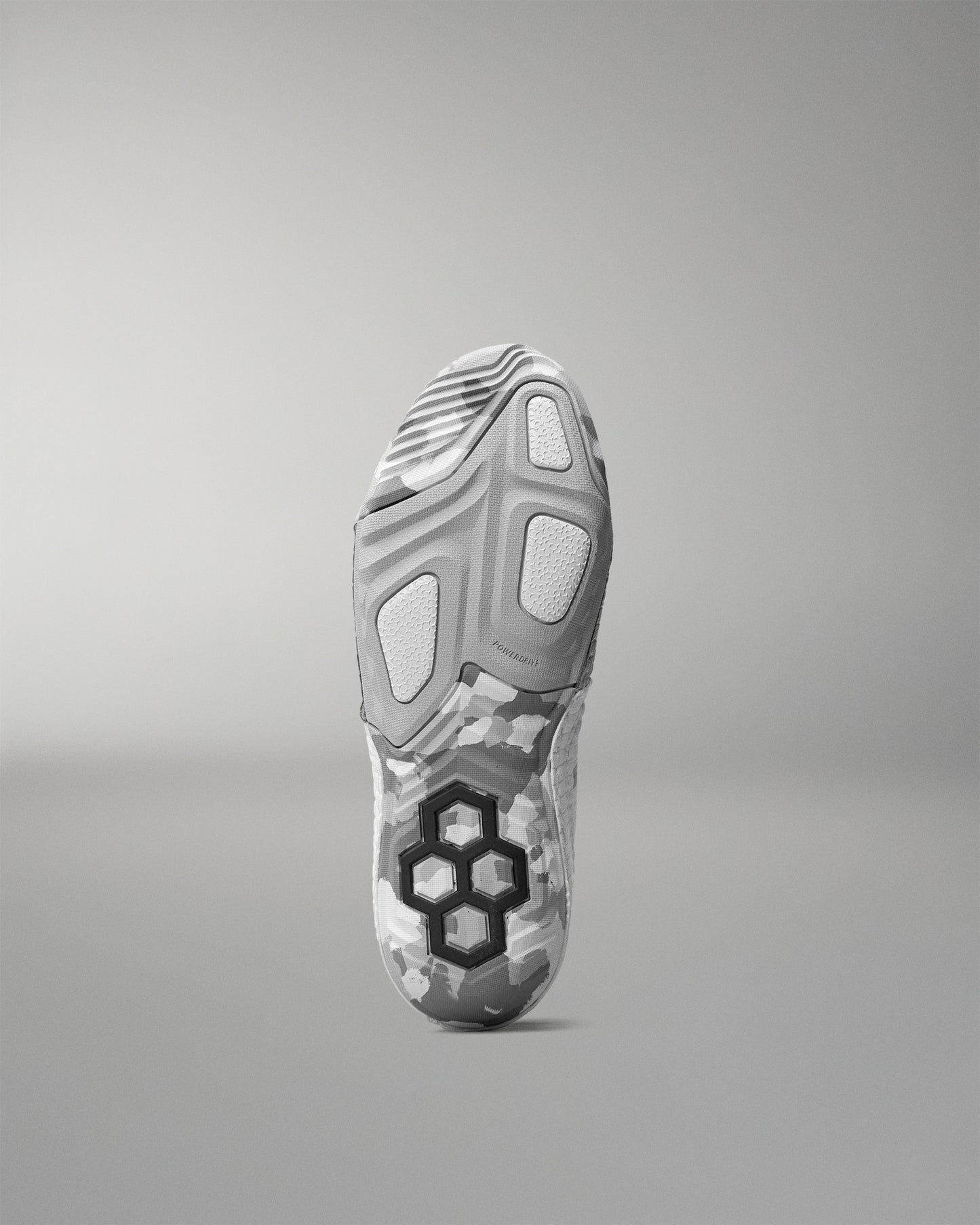 Gray wrestling shoe sole with a unique tread pattern on a gray background