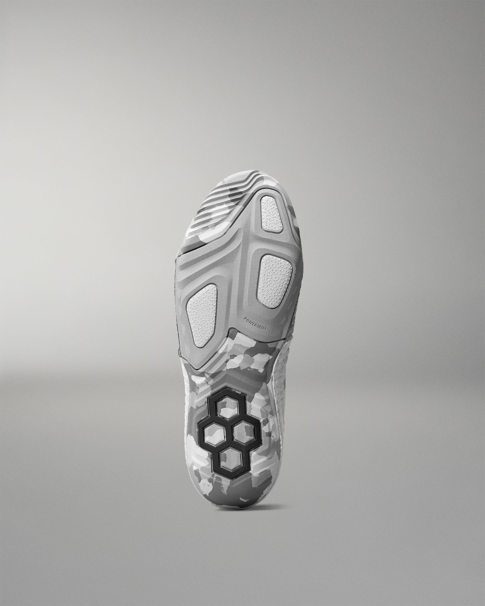 Gray wrestling shoe sole with a unique tread pattern on a gray background