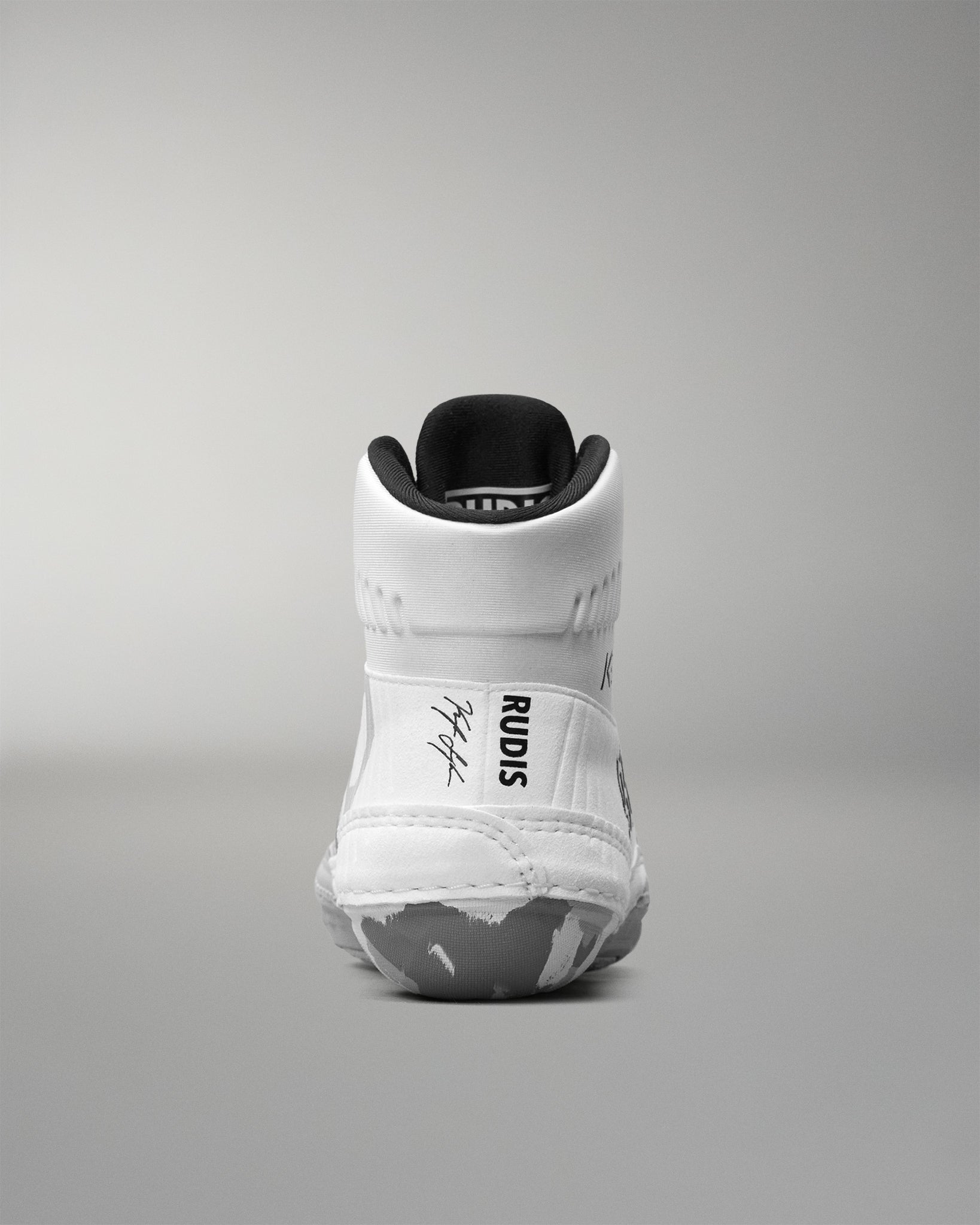 White wrestling shoe with black accents on a gray background