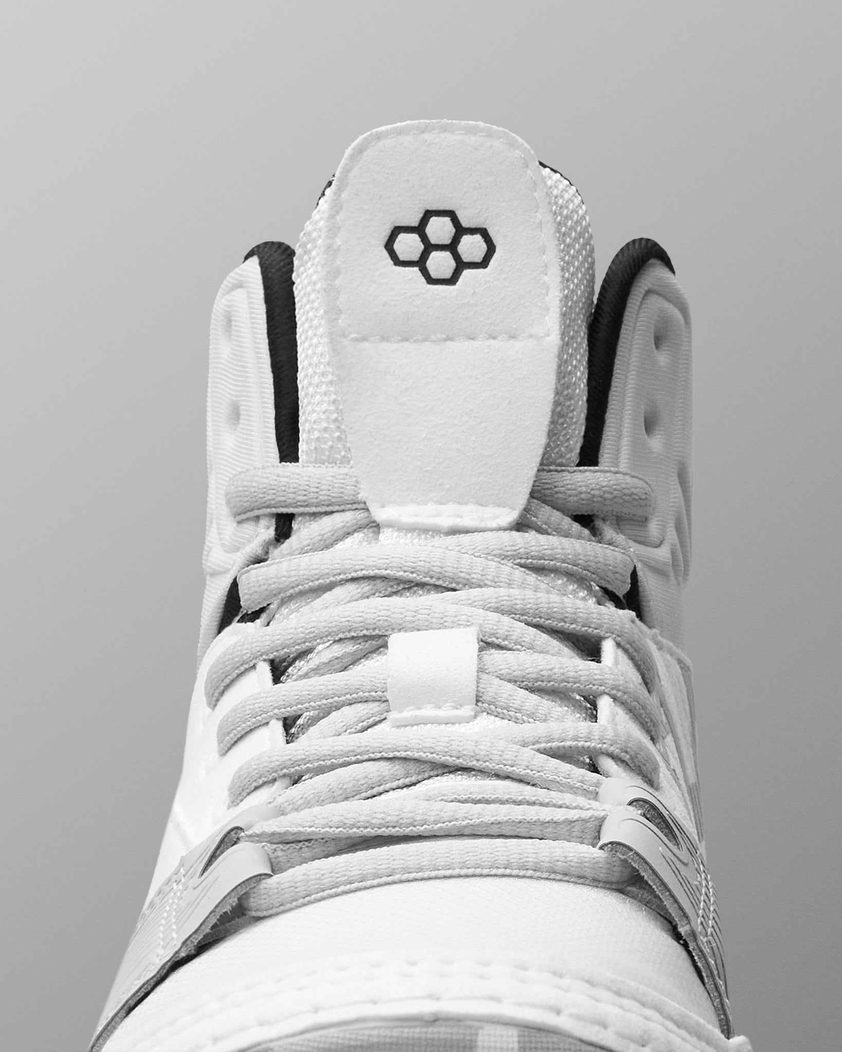 White wrestling shoe with black accents on a gray background