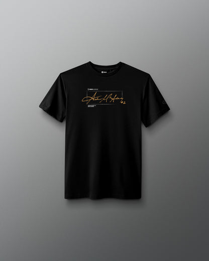 A black short-sleeve crewneck t-shirt with a gold and white graphic print on the chest, displayed against a dark gray gradient background.