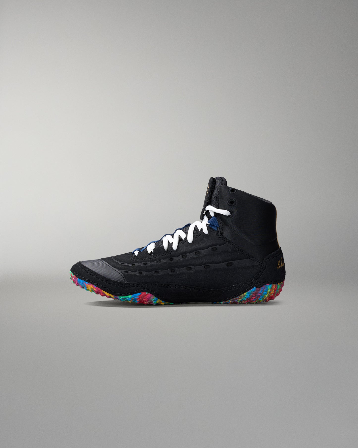 Black wrestling shoe with colorful sole on a gray background