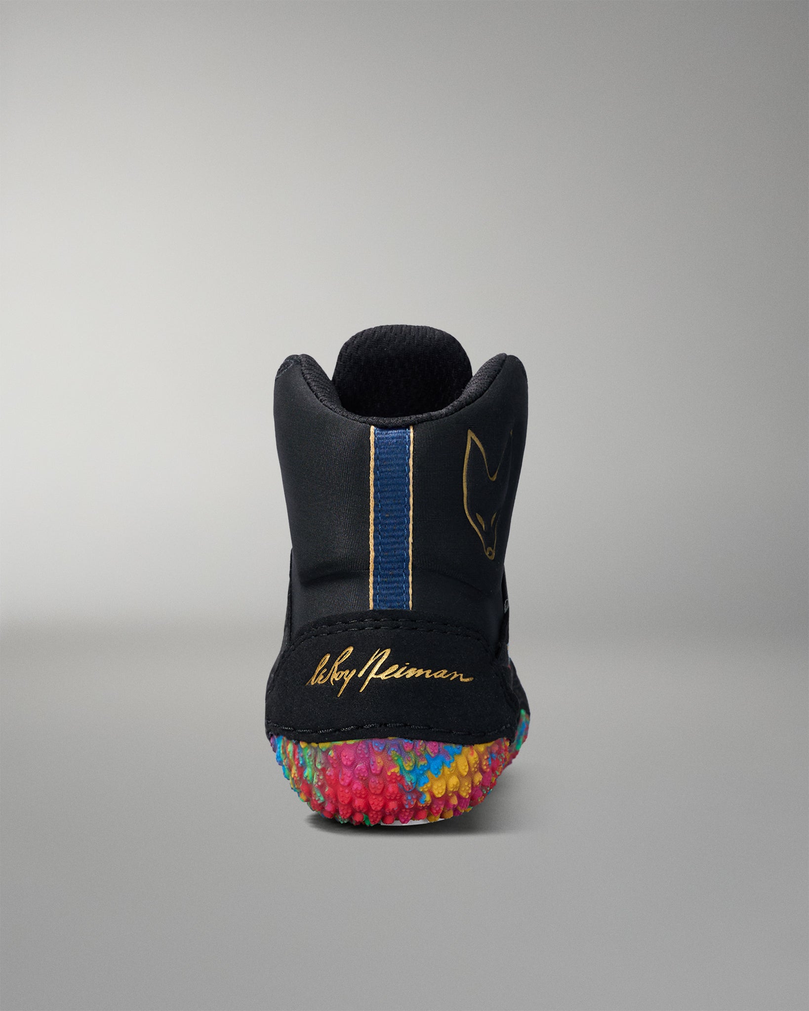 Black wrestling shoe with colorful sole on a gray background