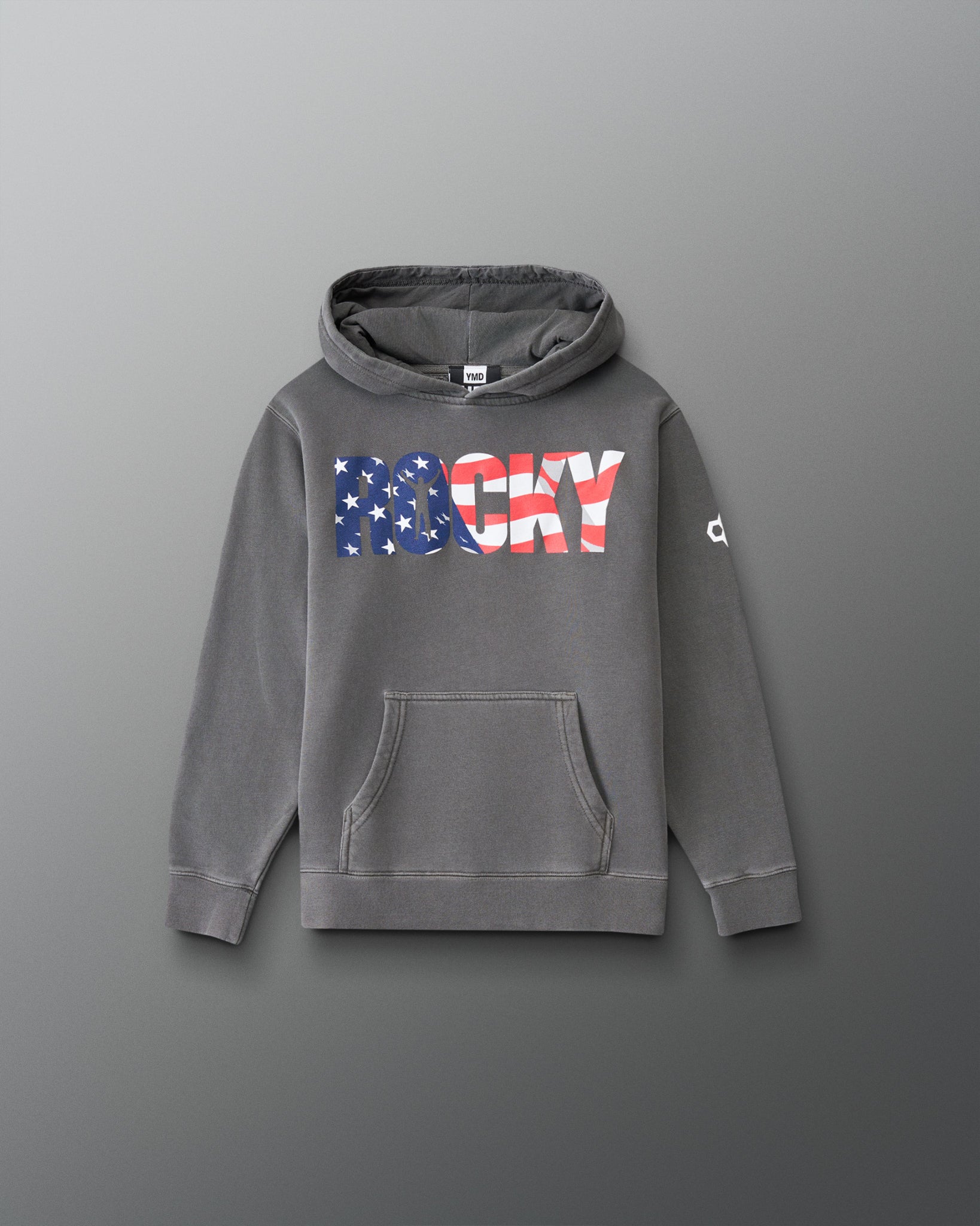 A gray pullover hoodie with a front kangaroo pocket and a large 'ROCKY' graphic across the chest in an American flag pattern. The word 'ROCKY' is filled with blue and white stars on the left side and red and white stripes on the right side.