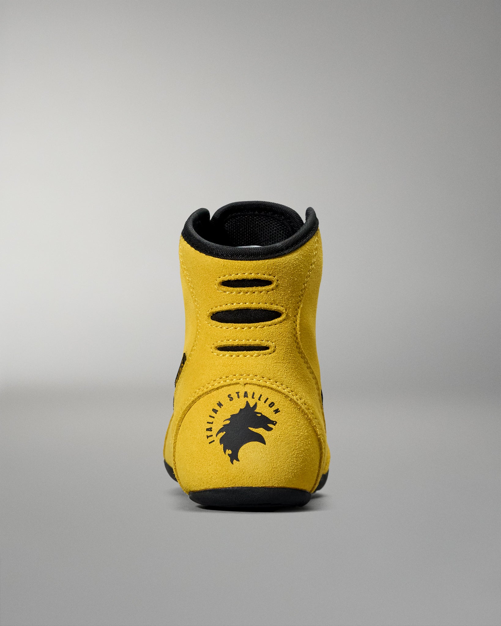 Yellow and black wrestling shoes on a gray background with Italian Stallion Rocky logo on heal of shoe