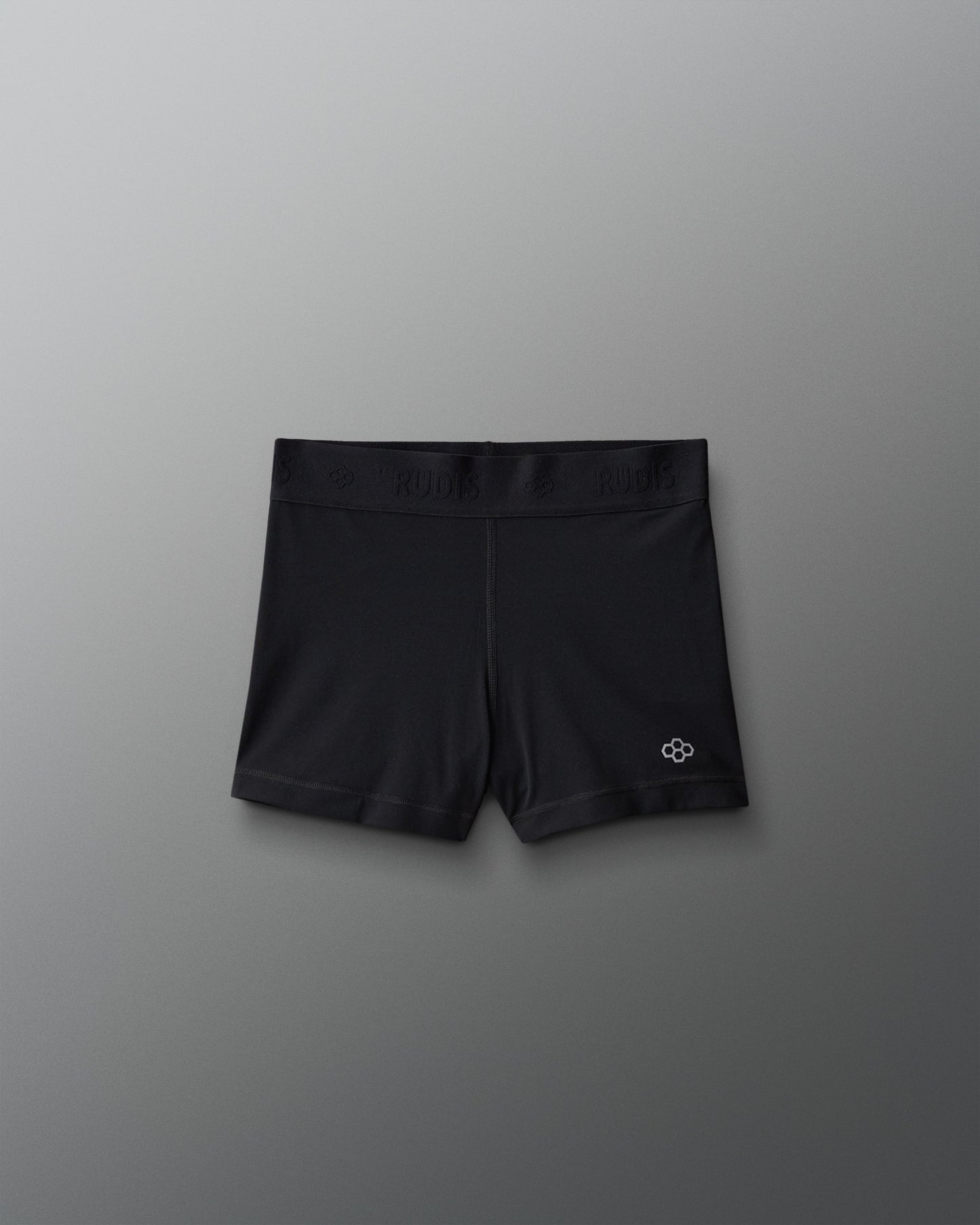 Black athletic shorts with a logo on a gray background