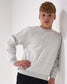 Person wearing a light gray Crewneck against a white background