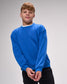 Person wearing a Royal blue sweatshirt against a gray background