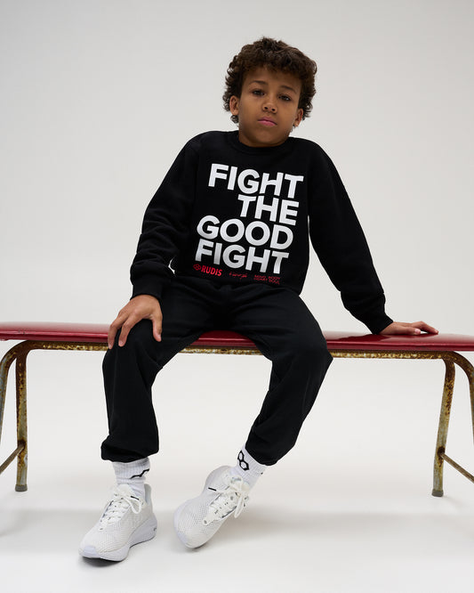 RUDIS Fight the Good Fight Youth Comfort Fleece Crewneck in Black, featuring bold white “FIGHT THE GOOD FIGHT” lettering with red RUDIS and motivational graphic details across the chest.