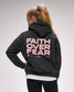 Person wearing a dark hoodie with 'Faith Over Fear' text on the back against a gray background