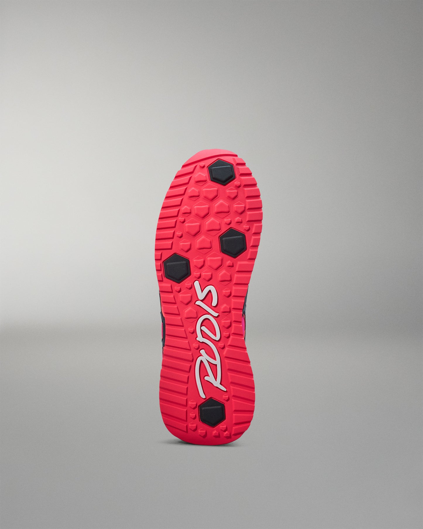 Red shoe sole with black accents on a gray background