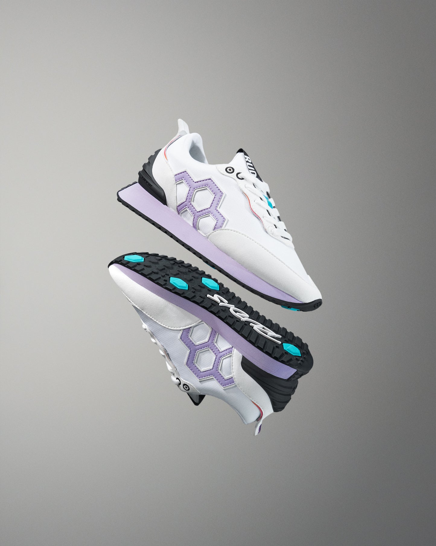 White sneakers with purple accents and black soles on a gray background