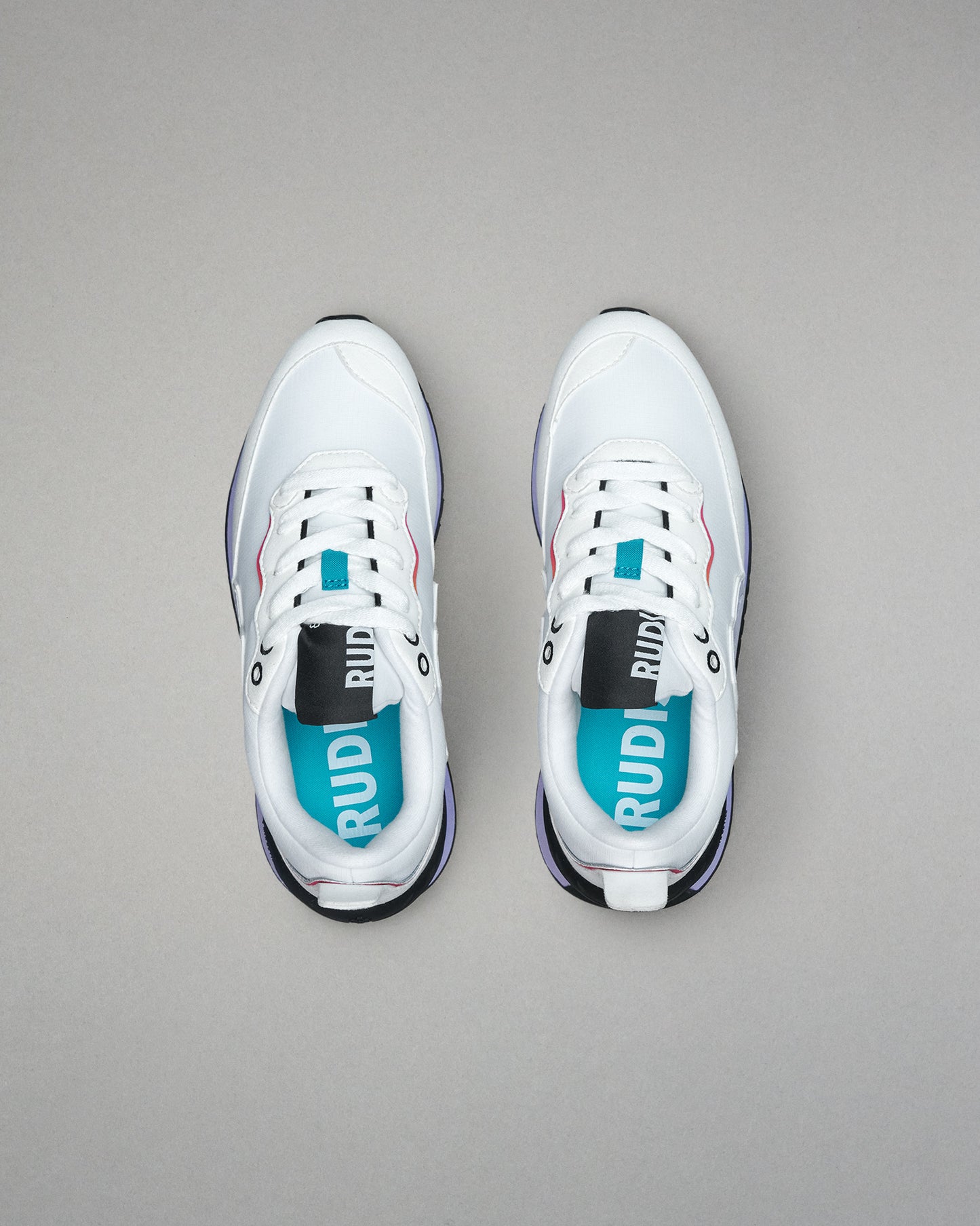 White sneakers with visible branding on a gray background