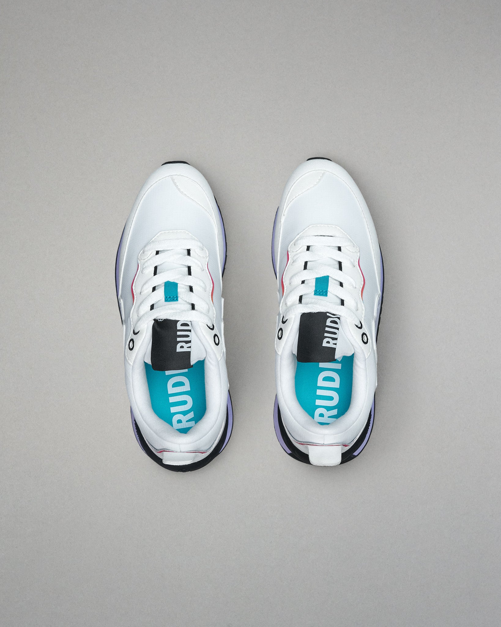 White sneakers with visible branding on a gray background