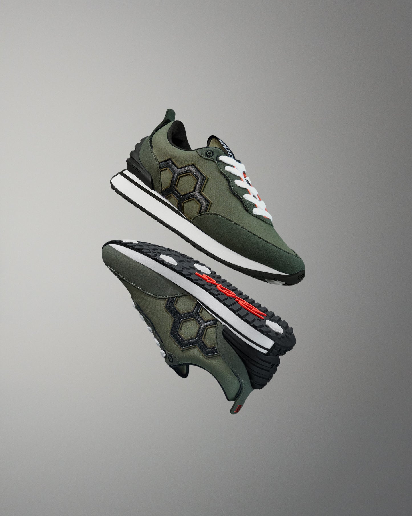 Green sneakers with white soles on a gray background