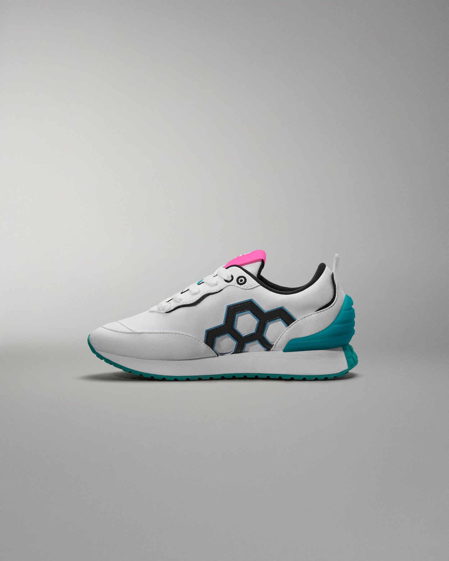 White sneaker with blue sole and pink accent on a gray background