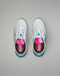 White sneakers with blue soles and pink labels on a gray background