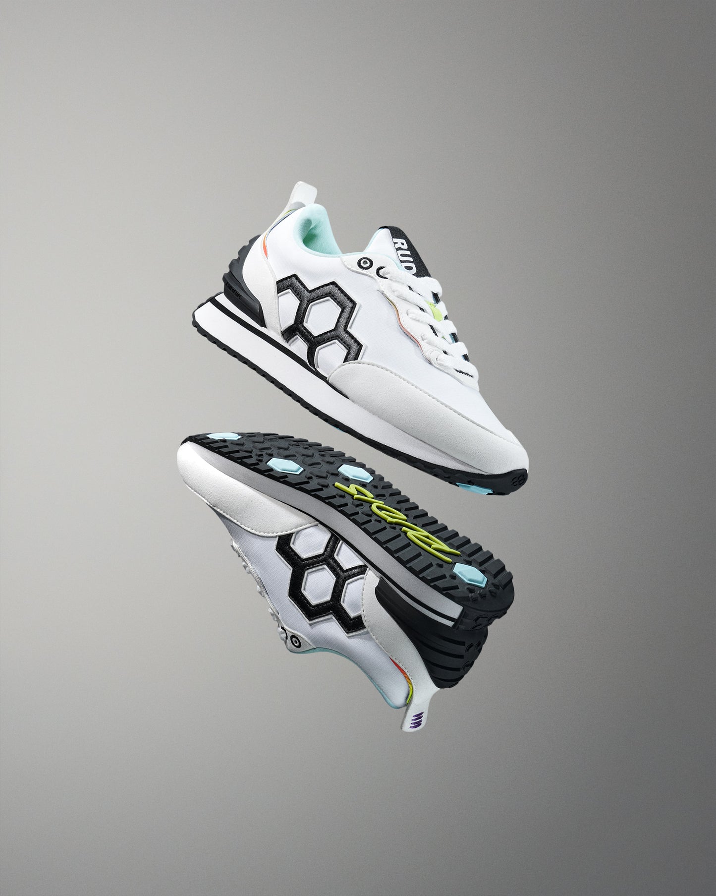 White athletic shoes with black and green accents on a gray background