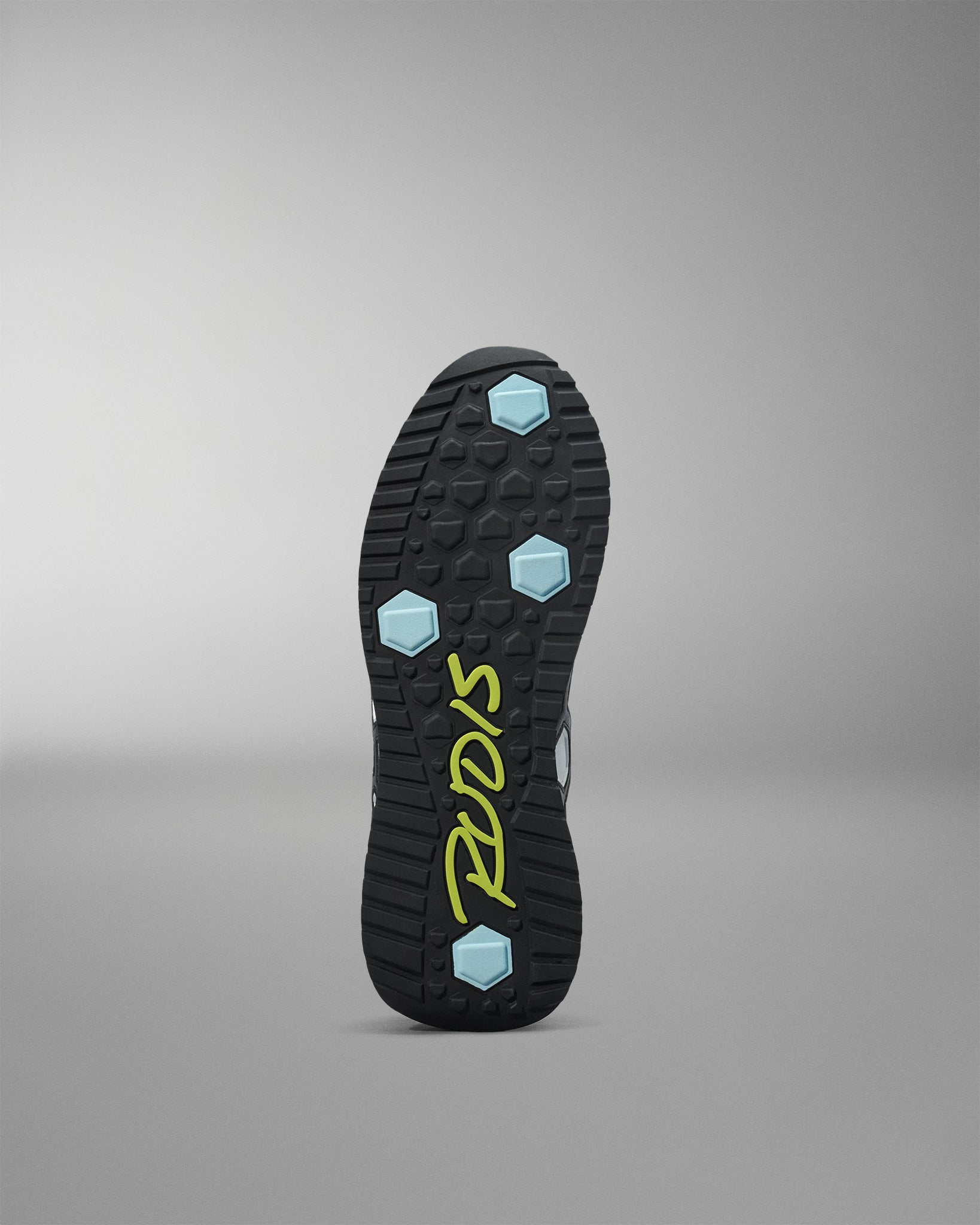 Black shoe sole with blue hexagonal patterns and 'Pryme' branding on a gray background