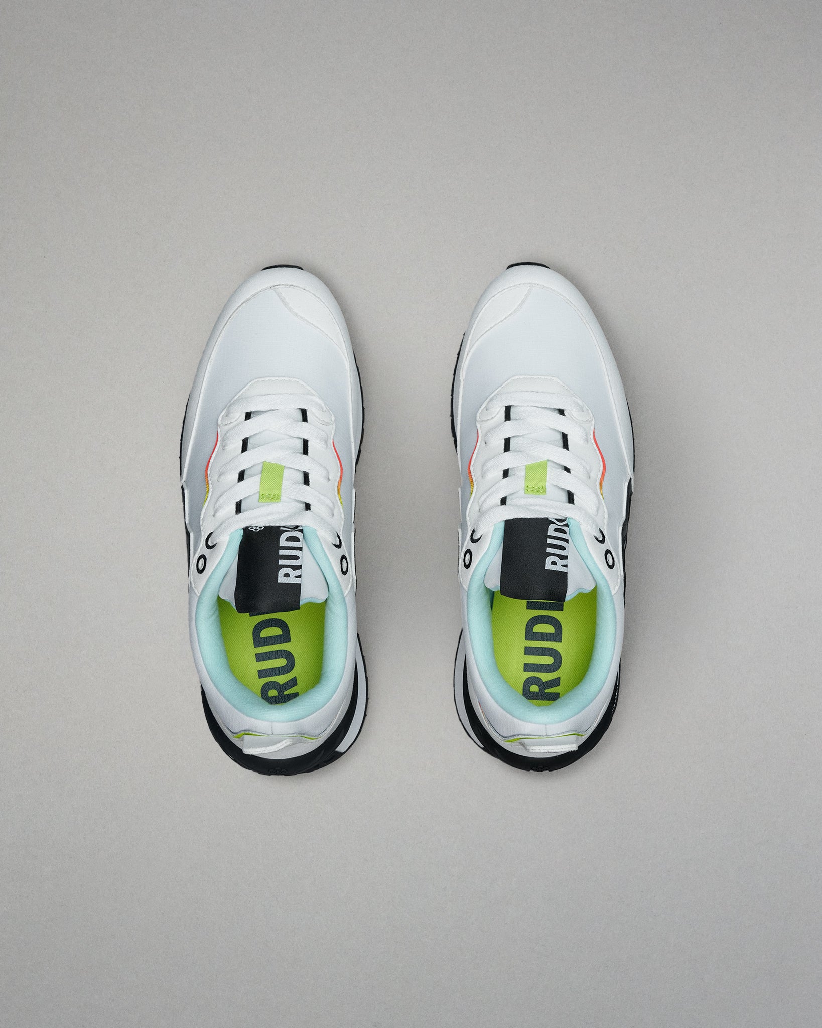 White sneakers with green accents on a gray background