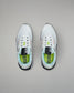 White sneakers with green accents on a gray background