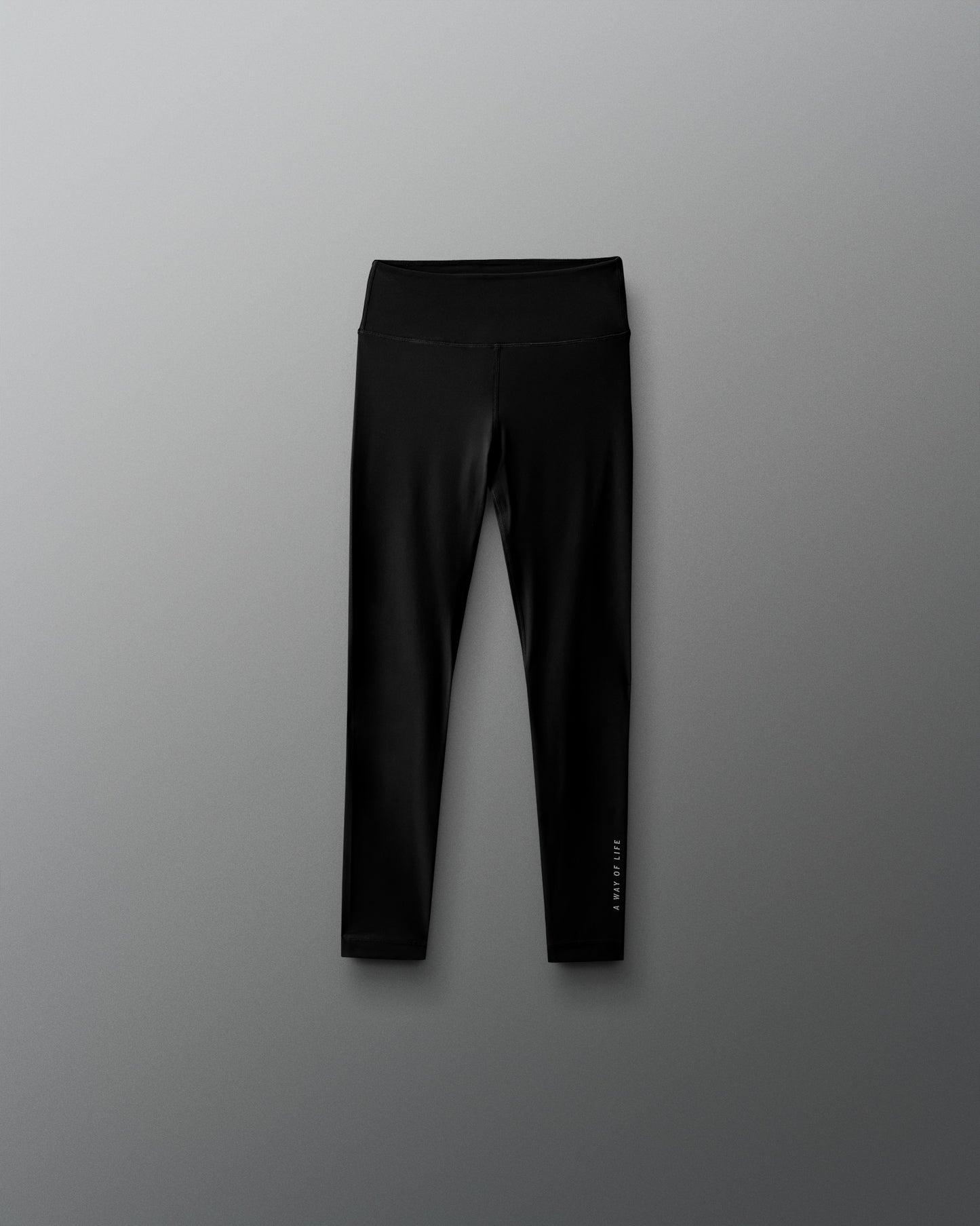 Black leggings with a brand logo on a gray background