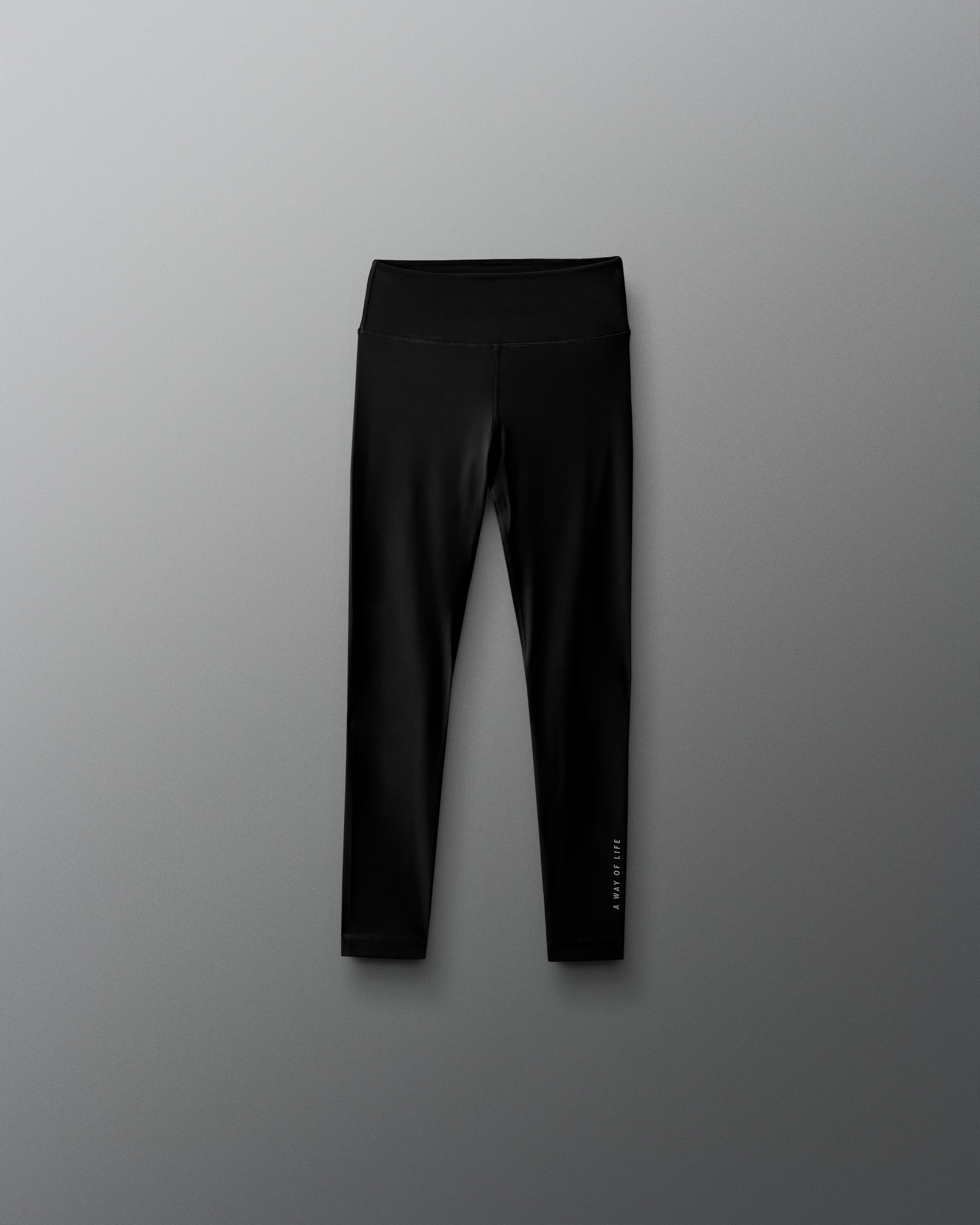 Black leggings with a brand logo on a gray background