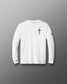 A white long-sleeve crewneck shirt with a black cross printed on the left chest and a small black logo on the right sleeve, displayed against a dark gray gradient background.