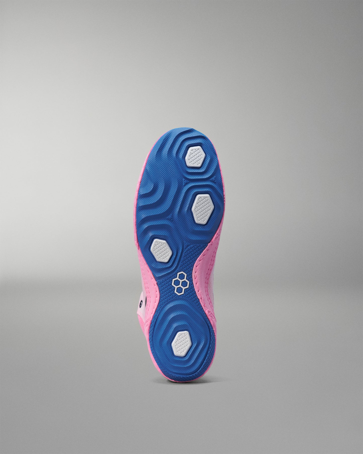 Close-up of a pink and blue wrestling shoe sole on a gray background