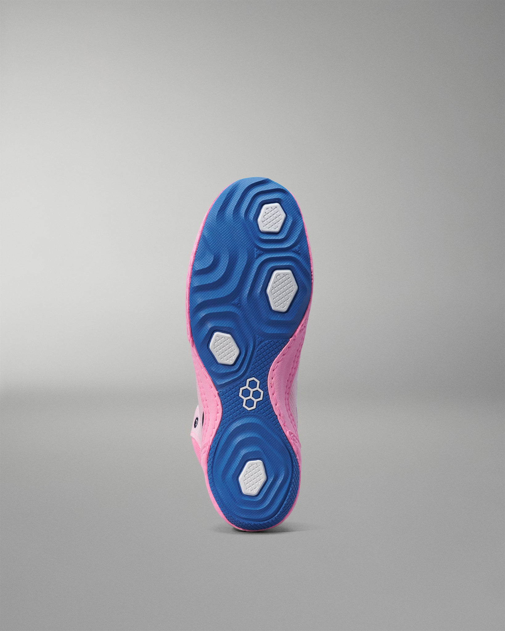 Close-up of a pink and blue wrestling shoe sole on a gray background