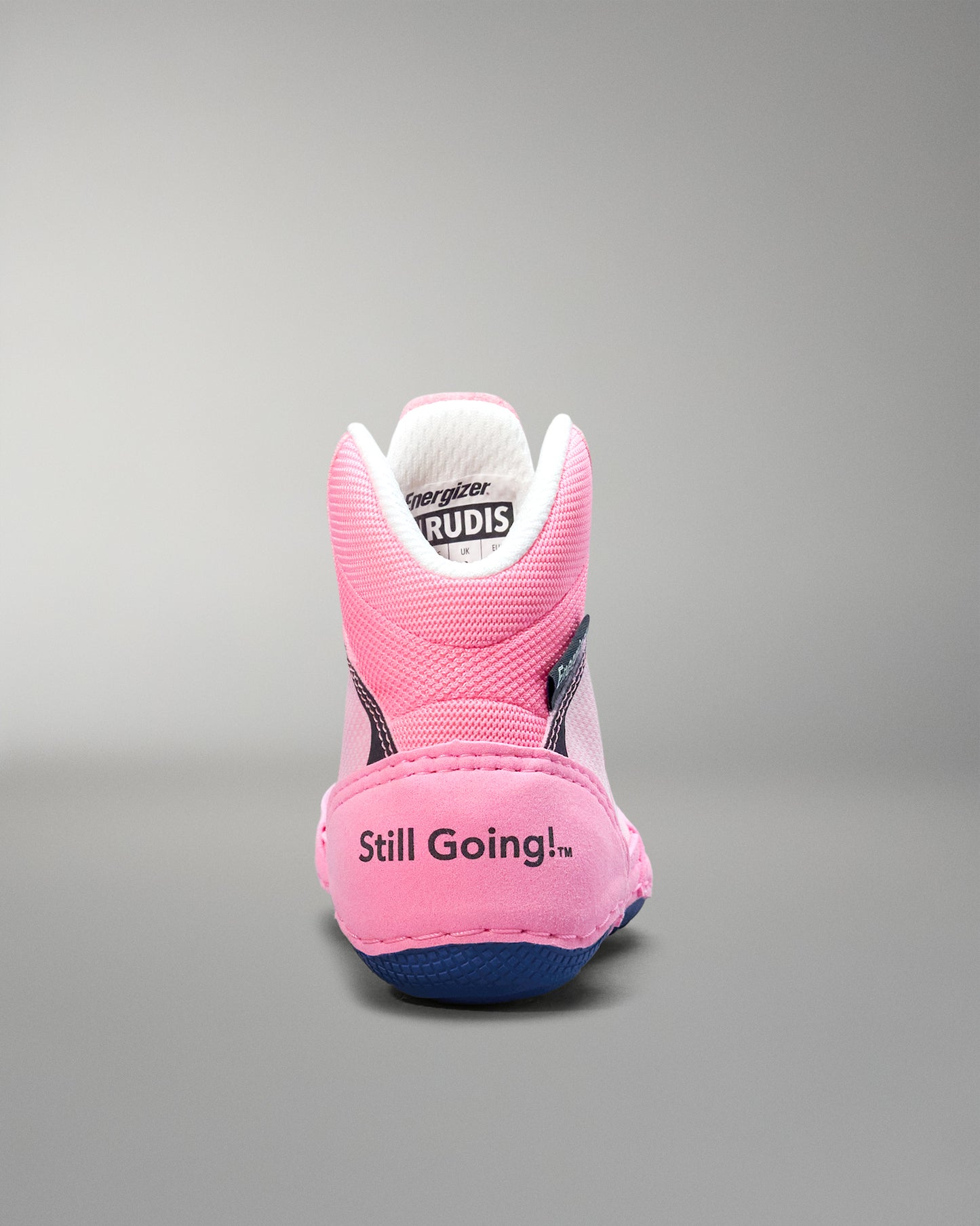 Pink wrestling shoe with 'Still Going!' text on a gray background