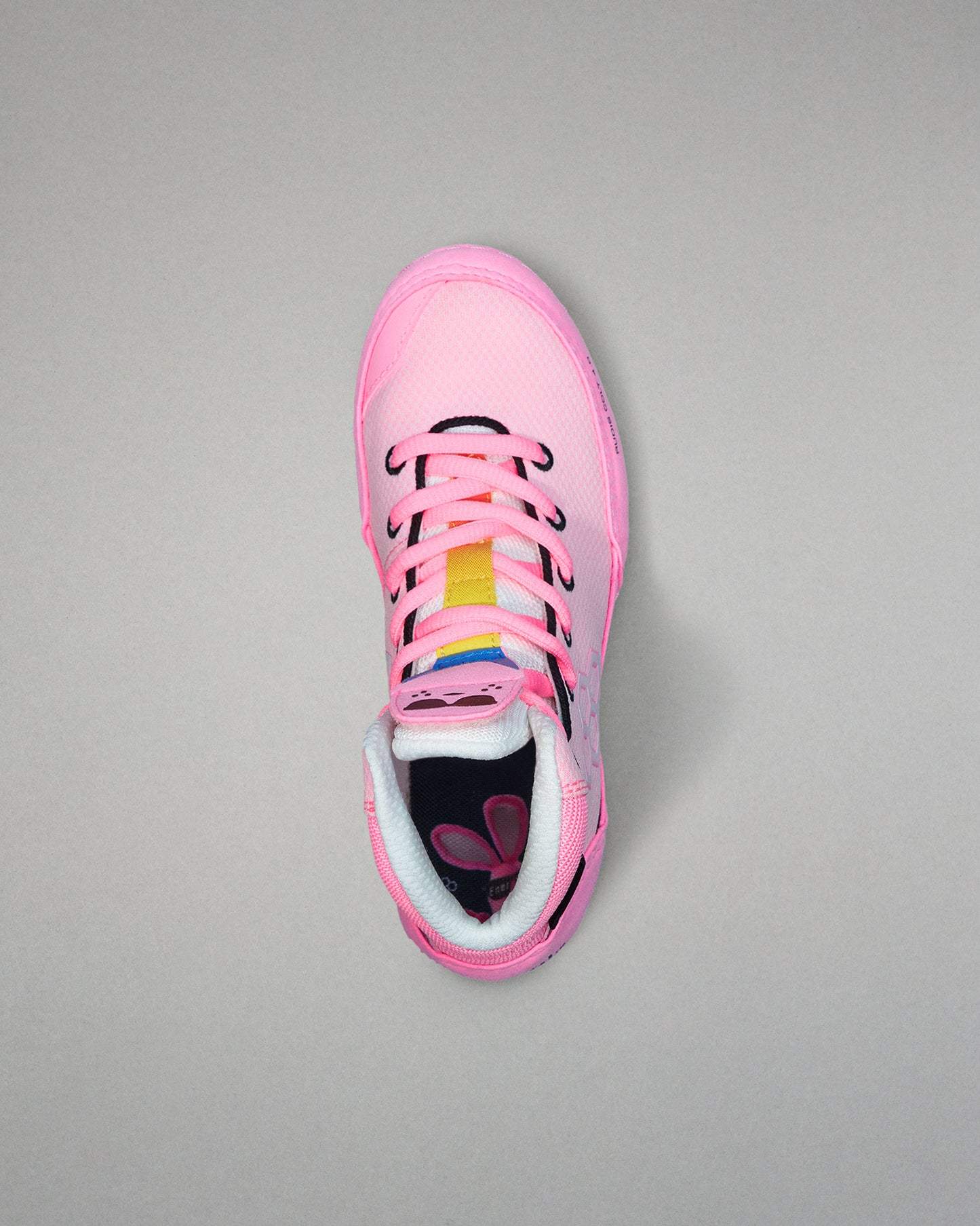 Pink wrestling shoe with colorful sole on a gray background