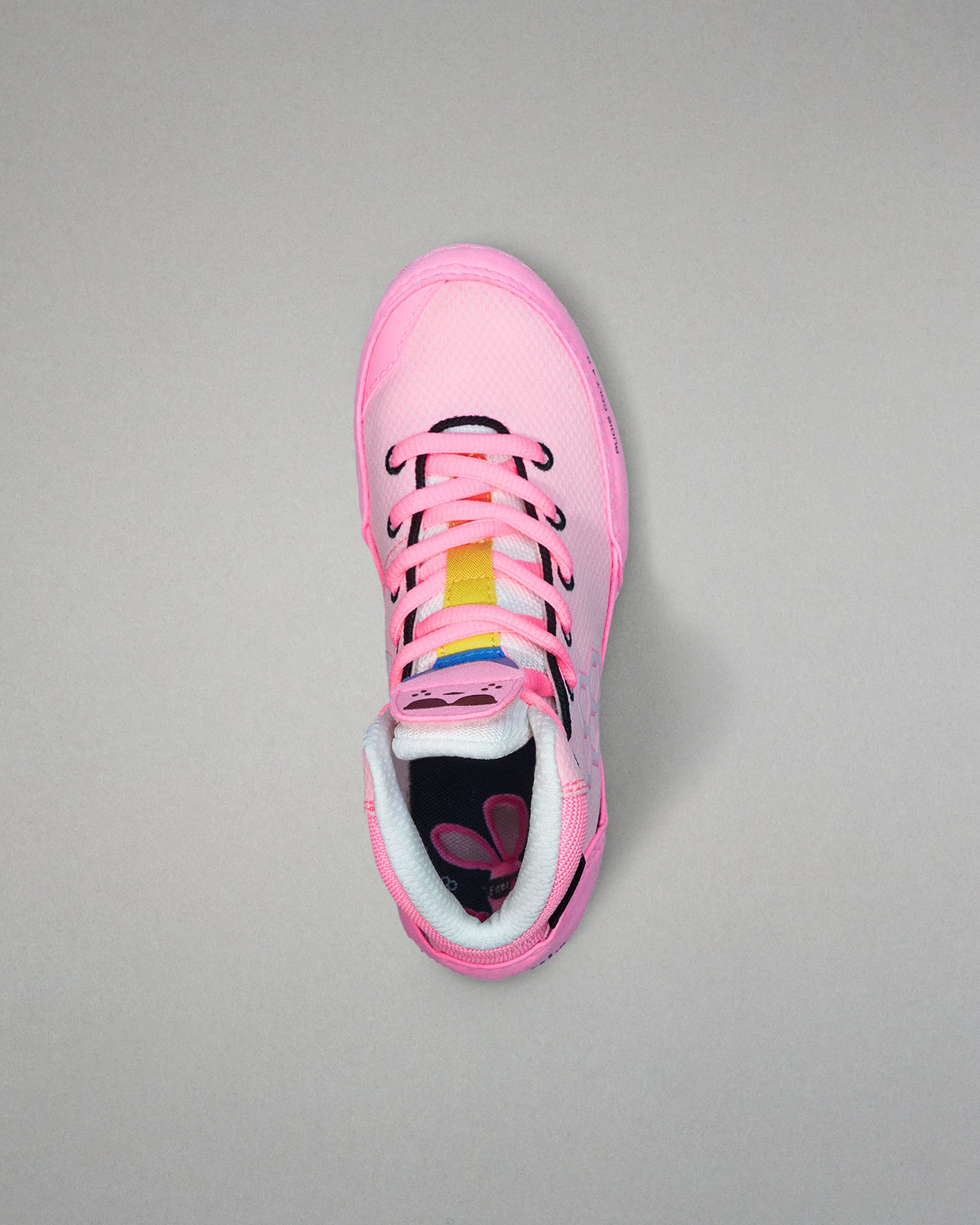 Pink wrestling shoe with colorful sole on a gray background
