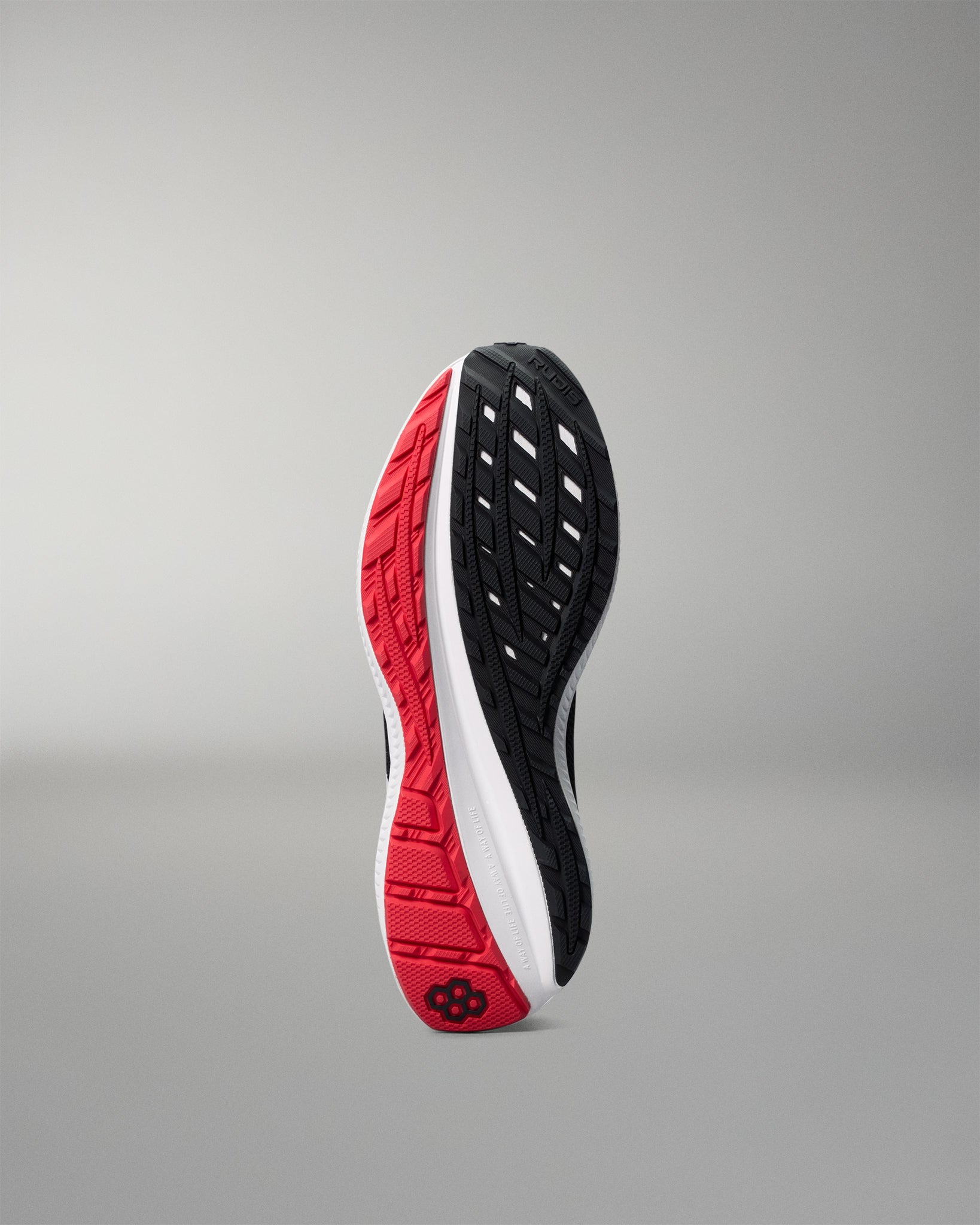 Sole of a running shoe with red, black, and white design on a gray background