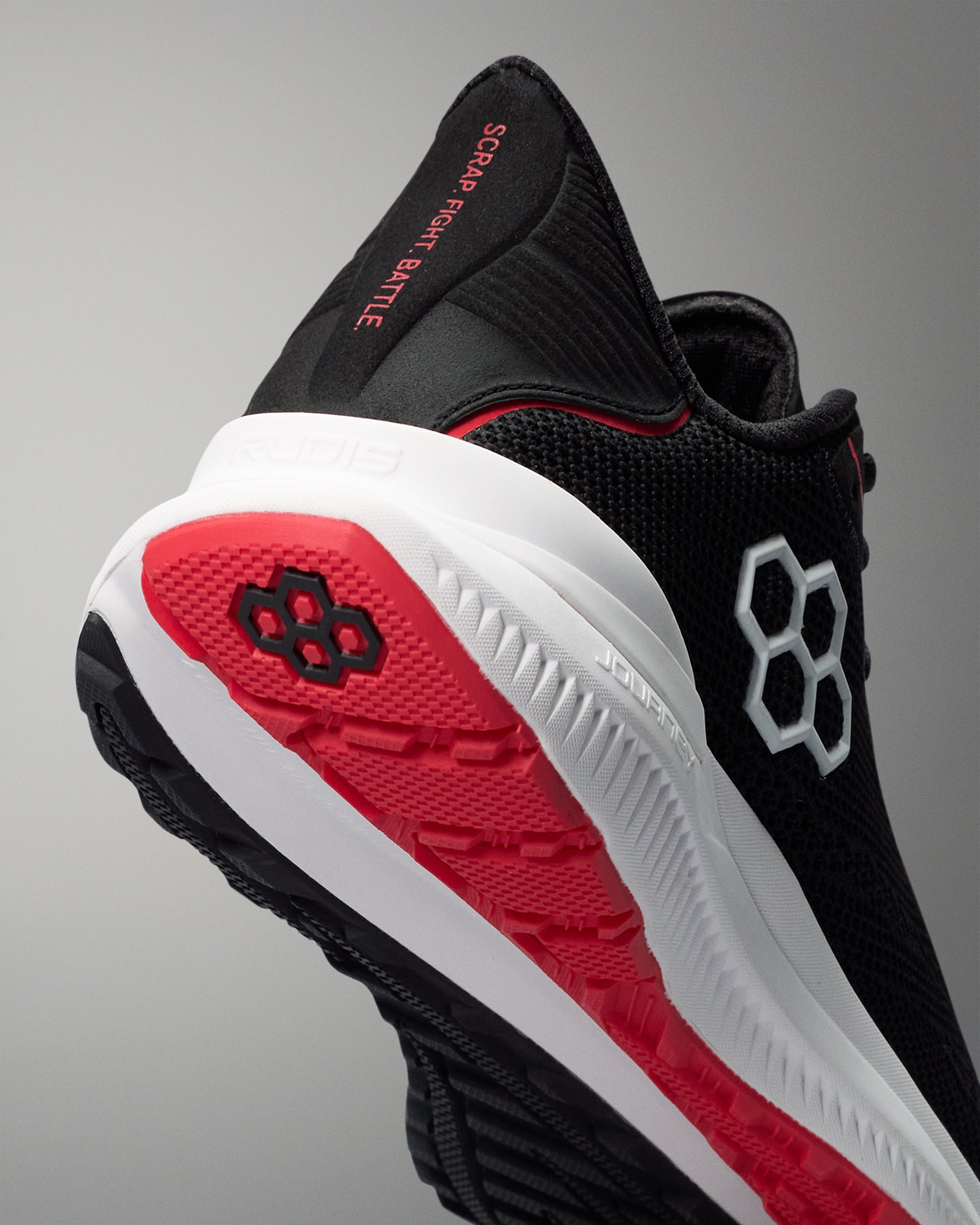 Black and red athletic shoe with visible branding on a gray background