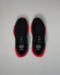 Top view of a pair of black RUDIS training shoes with red midsoles and black laces. The insoles display a white hexagon logo and the word ‘JOURNEY.’ Shoes are positioned side by side on a light gray background.