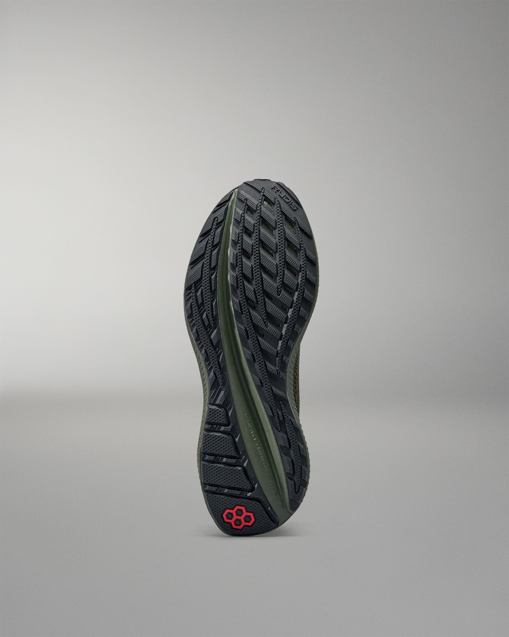 Black and green training shoe sole on a gray background