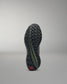Black and green training shoe sole on a gray background