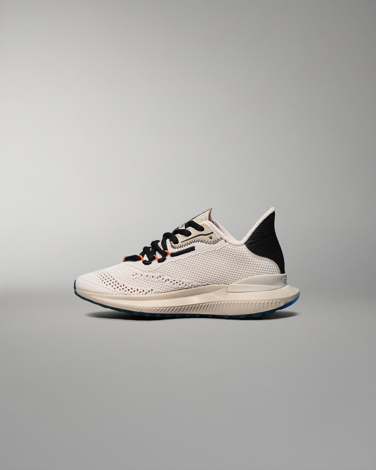White training shoe with black accents on a gray background