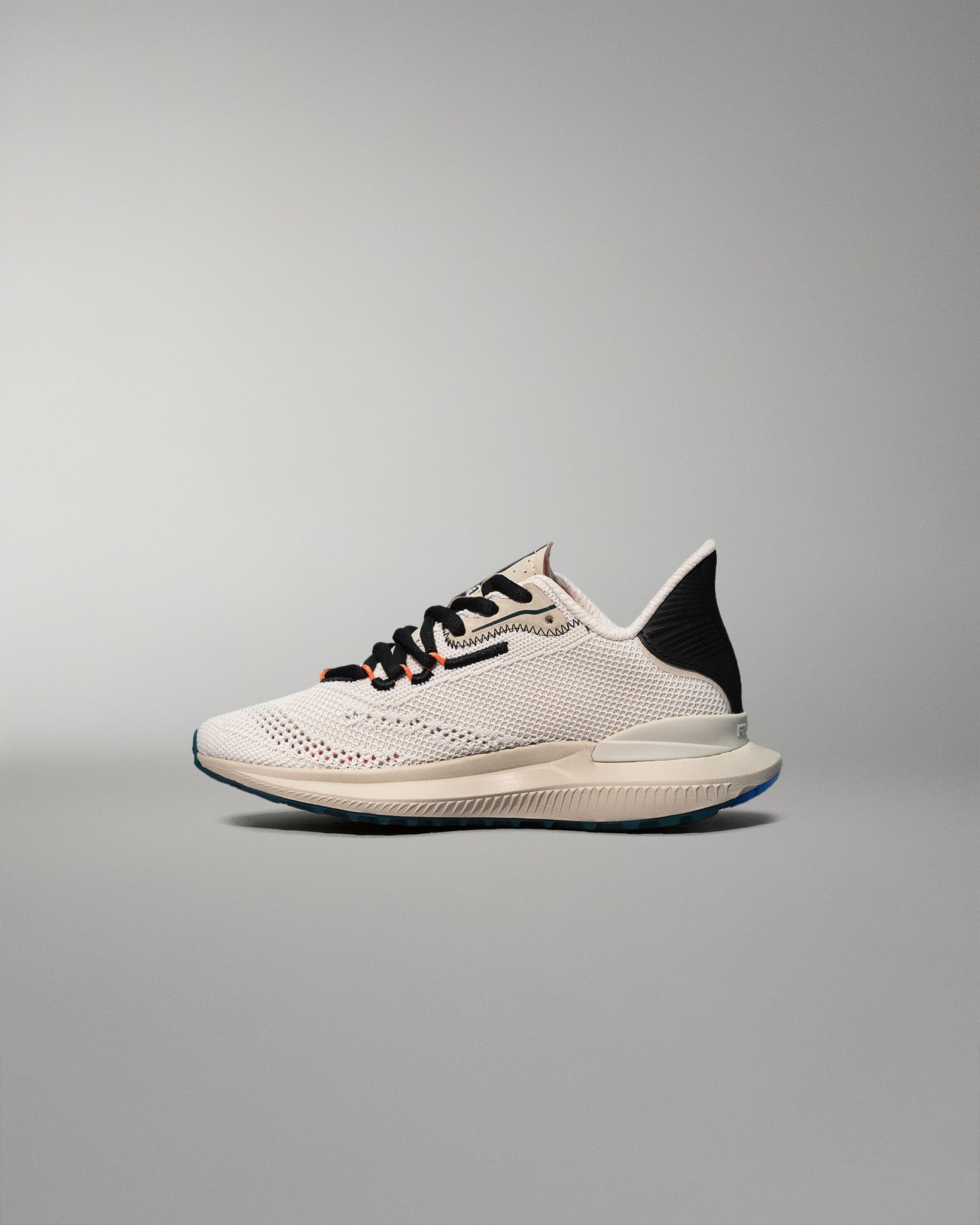White training shoe with black accents on a gray background