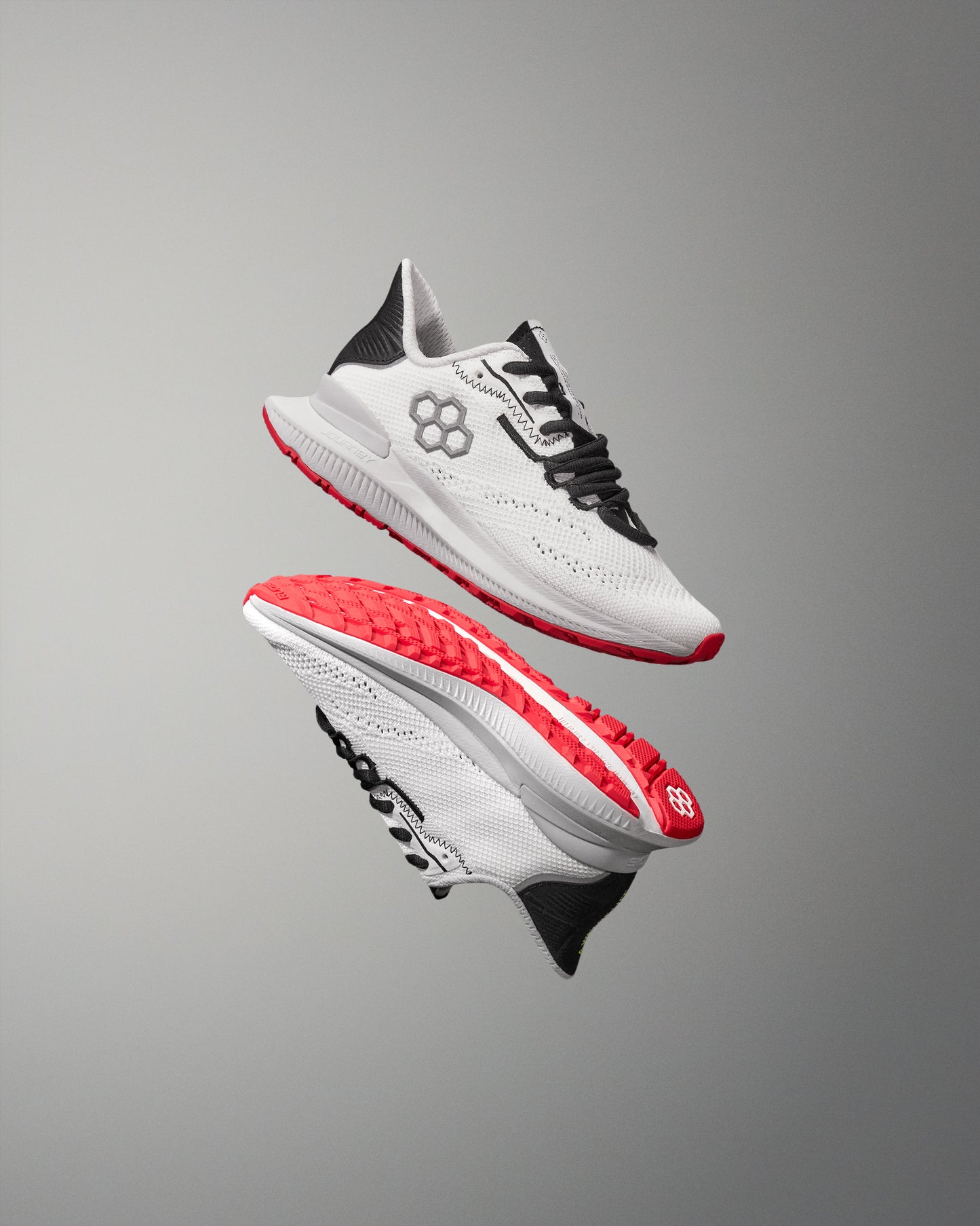 White training shoe with red soles on a gray background