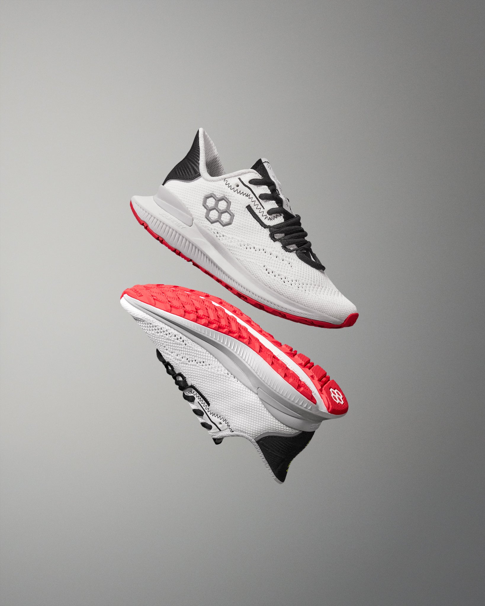 White training shoe with red soles on a gray background