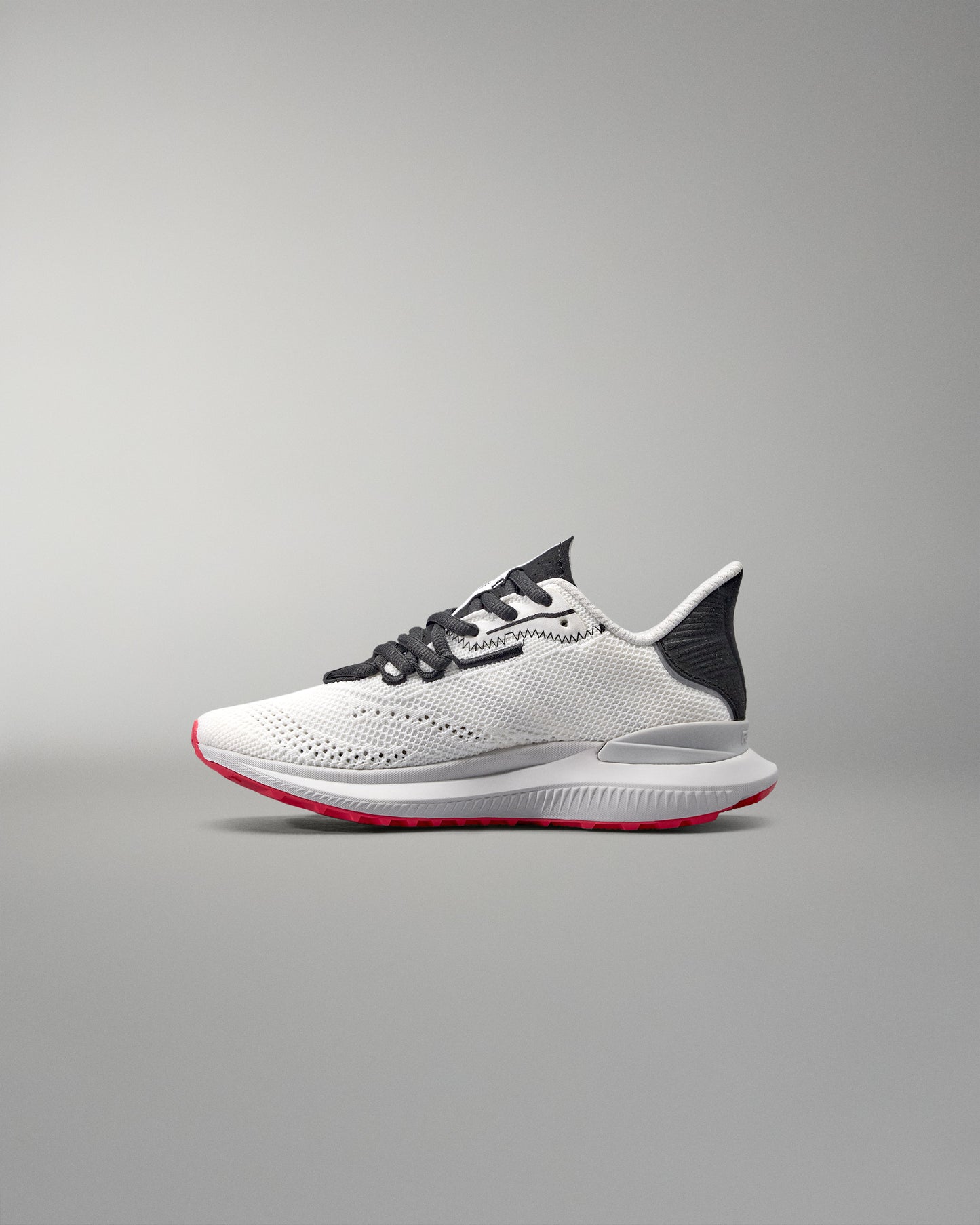 White running shoe with black and red accents on a gray background