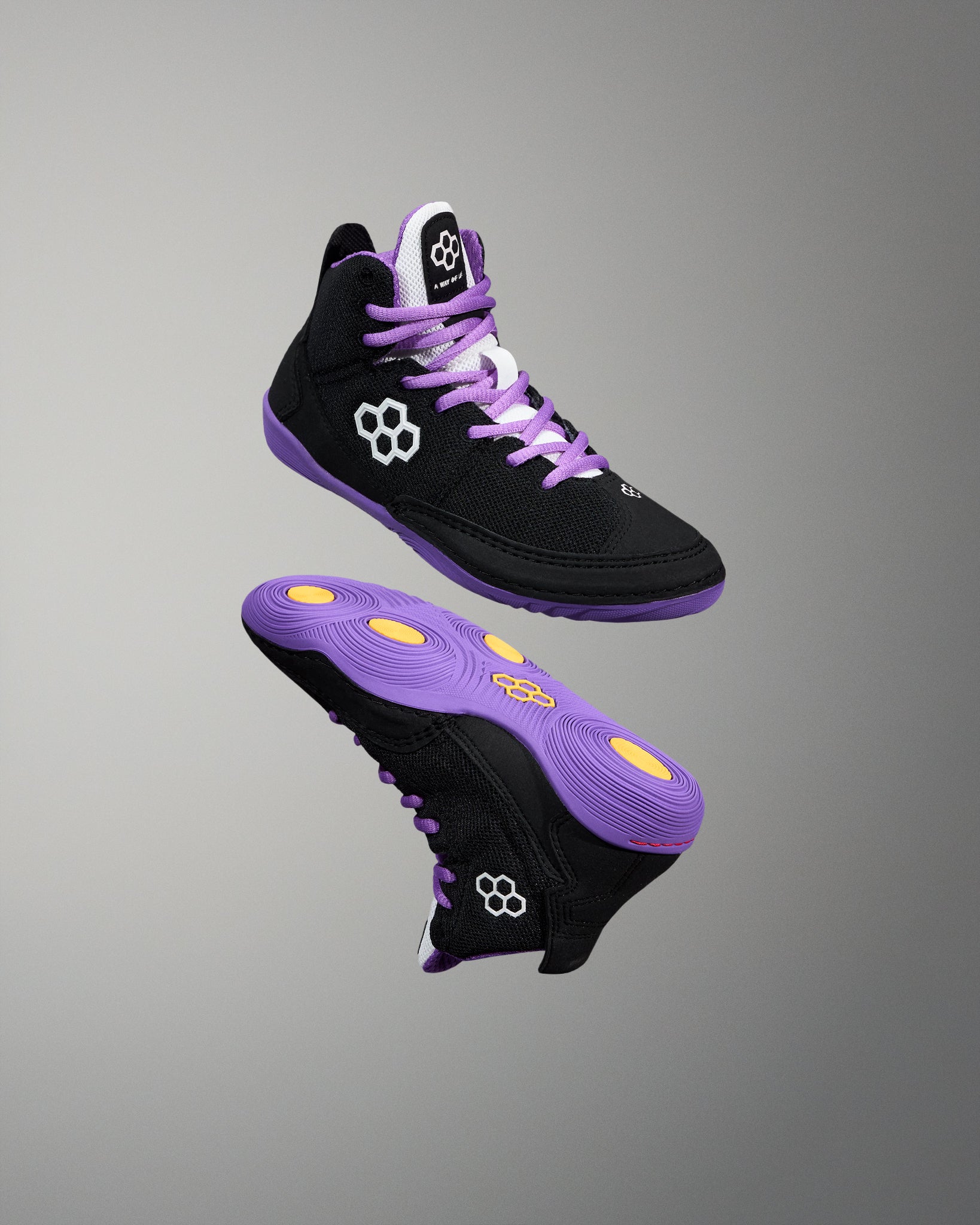 Black and purple high-top sneakers with yellow accents on a gray background