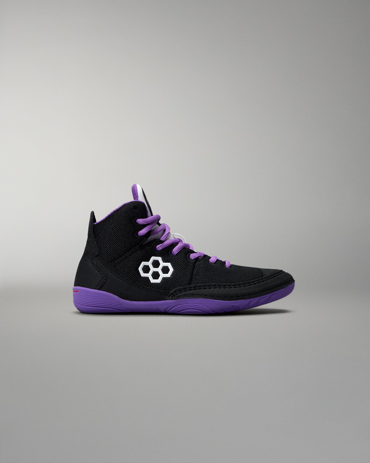 Black high-top sneaker with purple accents on a gray background