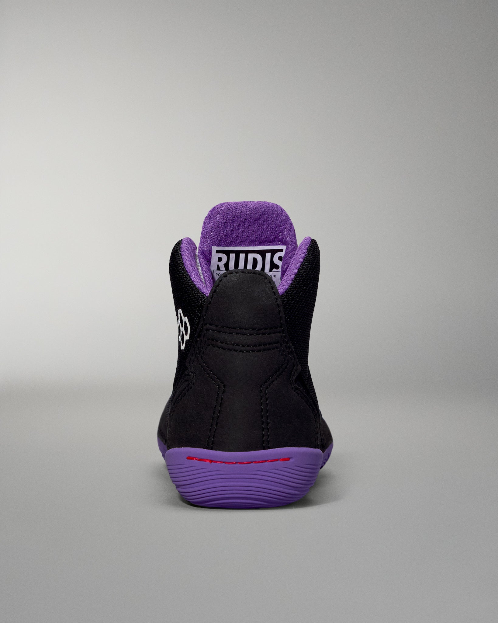 Black and purple sneaker with visible brand logo on a gray background