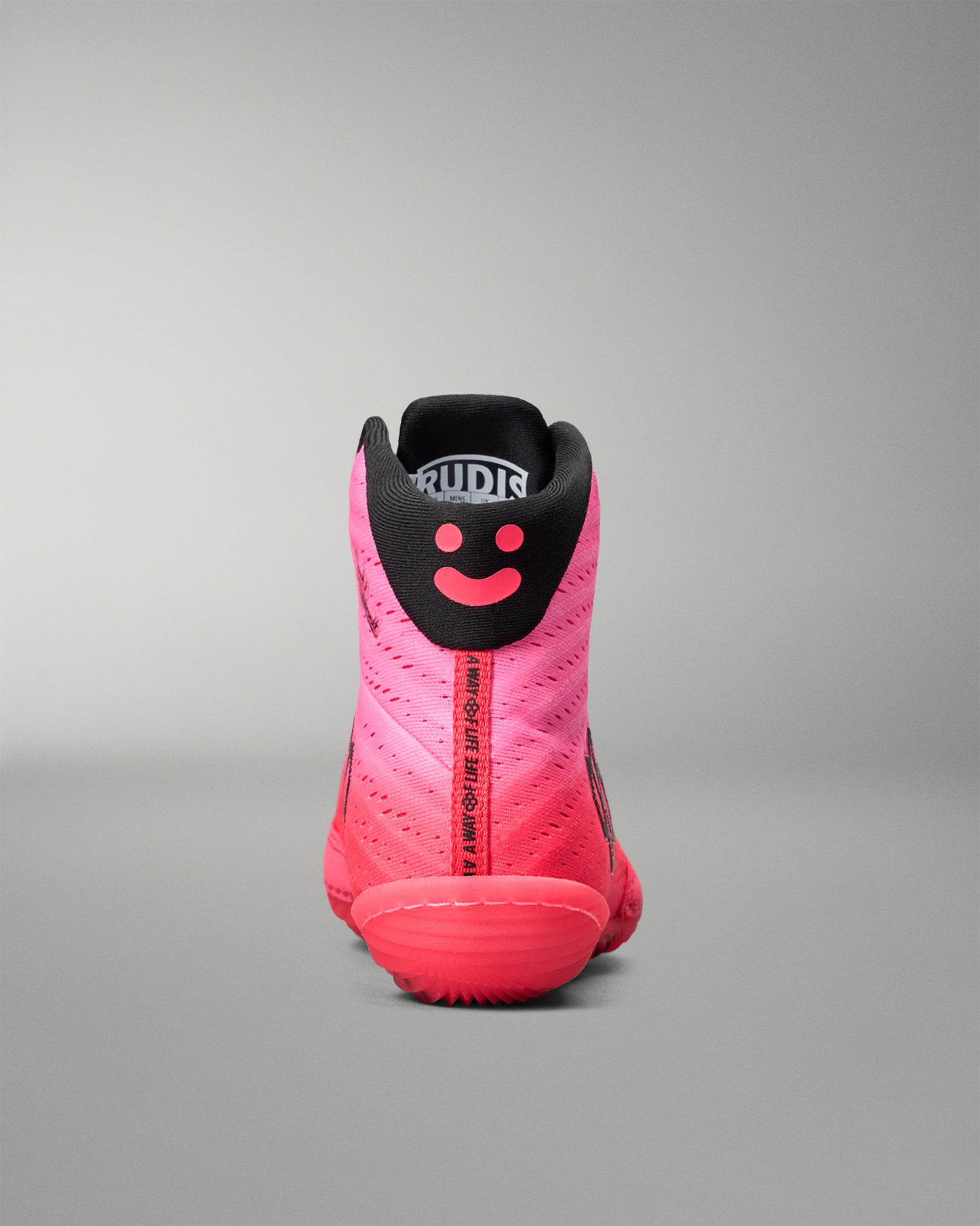 Pink and black wrestling shoe with a smiley face design on a gray background